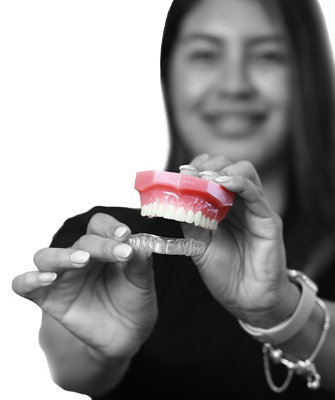 Dental team member holding a smile model and clear aligner