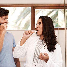 Couple brushing their teeth in bathroom