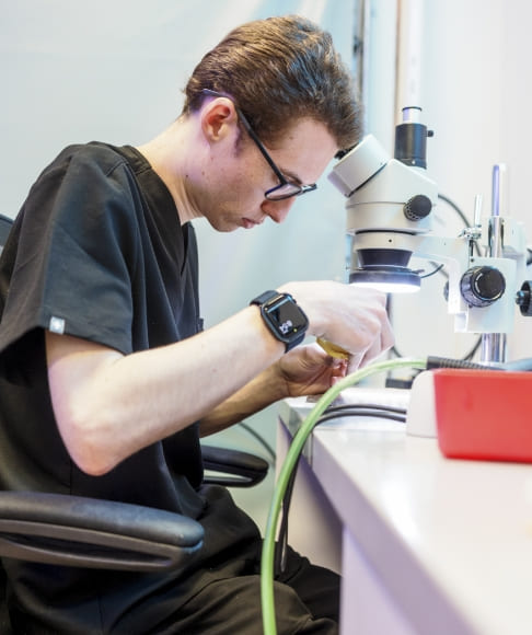 Dental lab technician making adjustments to dental restoration