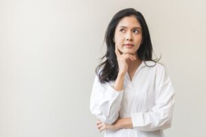 Woman in white blouse wearing curious expression